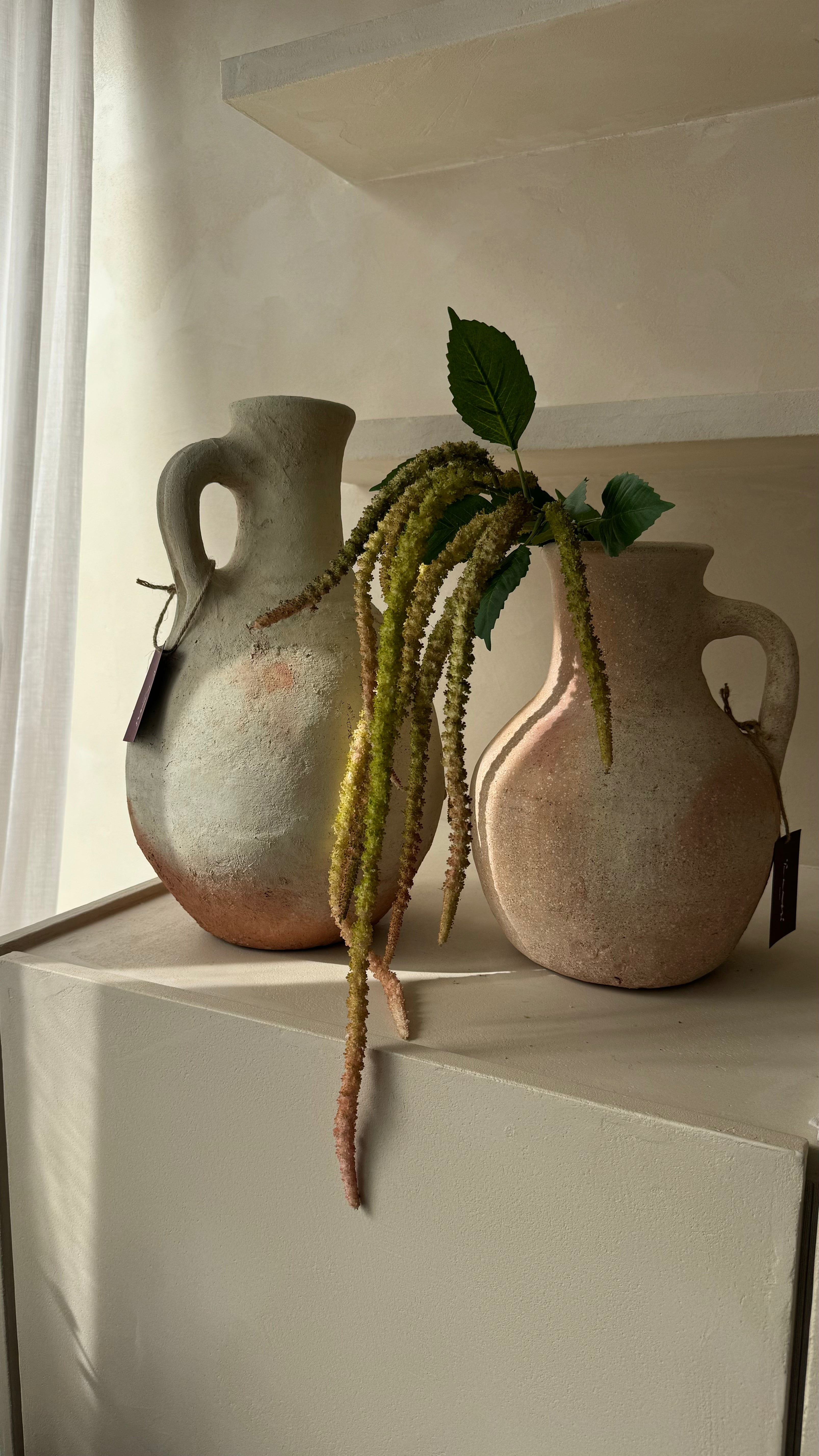 Hangende groene Amaranthus kunsttak gestyled in een hoge vaas