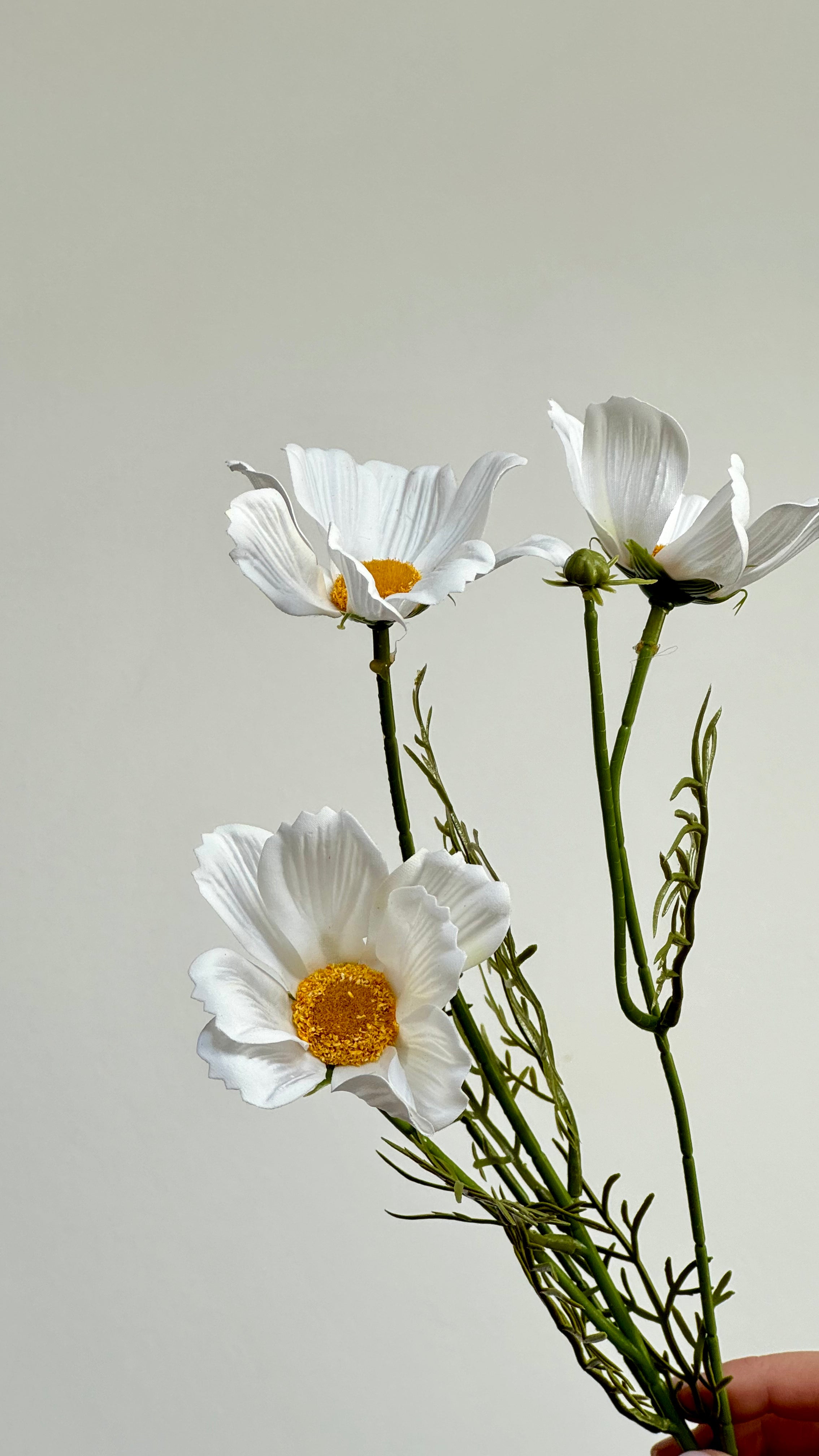 Close-up van de witte bloemblaadjes en goudgele kern van de Cosmo Daisy kunstbloem