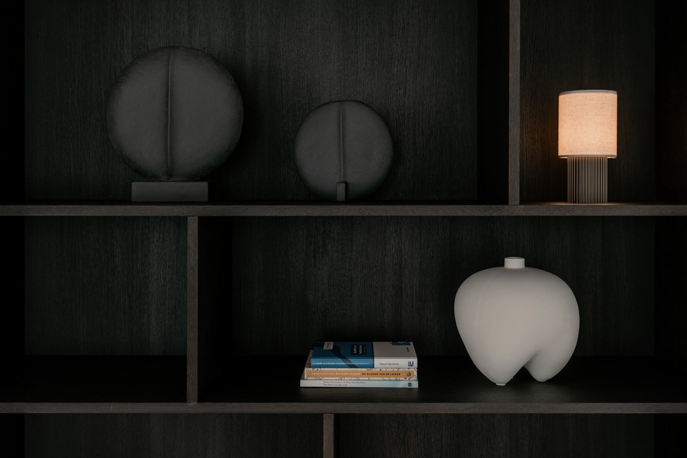 Een wandkast gevuld met 2 Guggenheim vazen, een draagbare lamp en een Sumo vaas van 101 Copenhagen verkocht door Anneke Crauwels Home