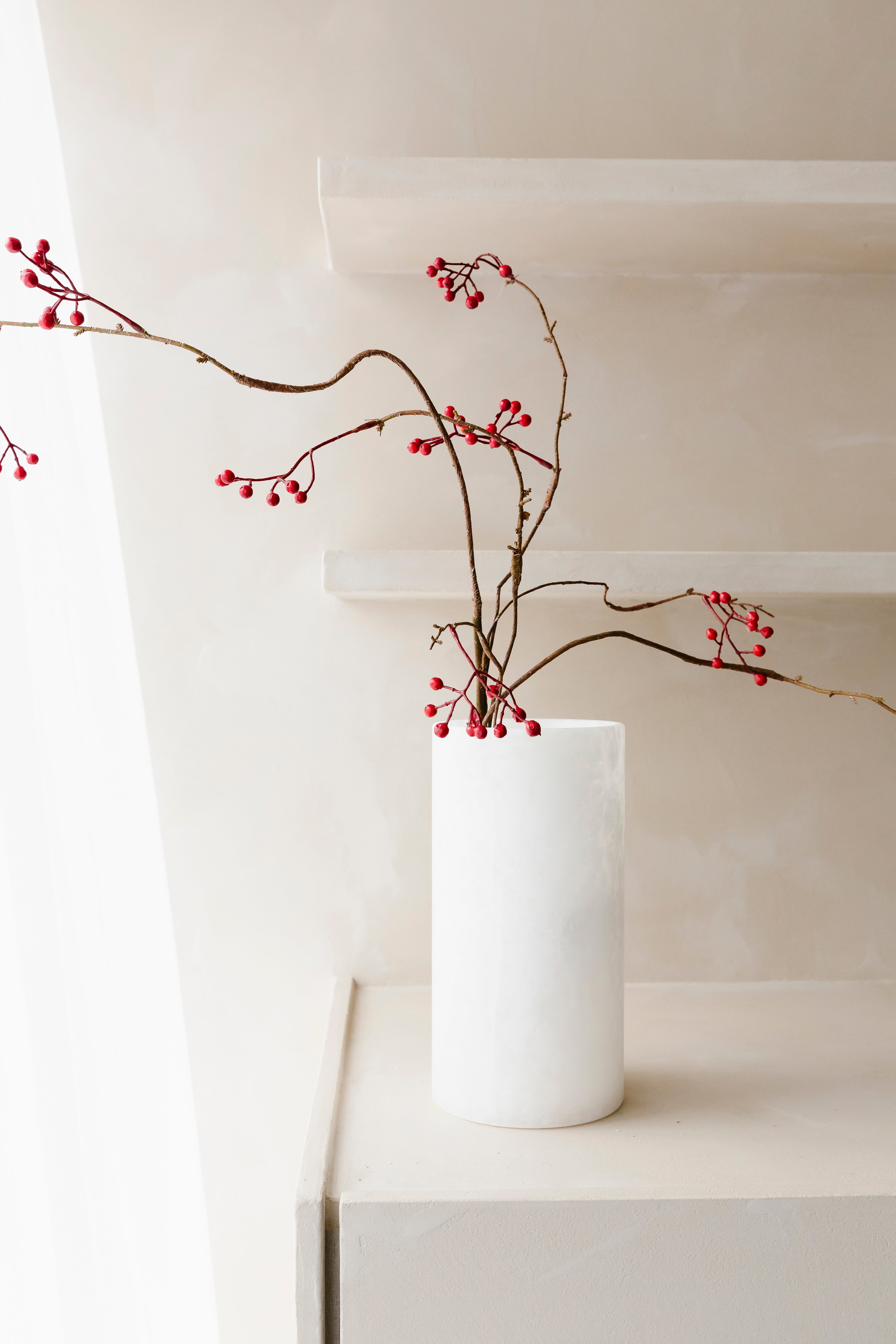 Styling van bessentak 127cm met rode bessen in een vaas uit Albast op kast - Collectie Anneke Crauwels