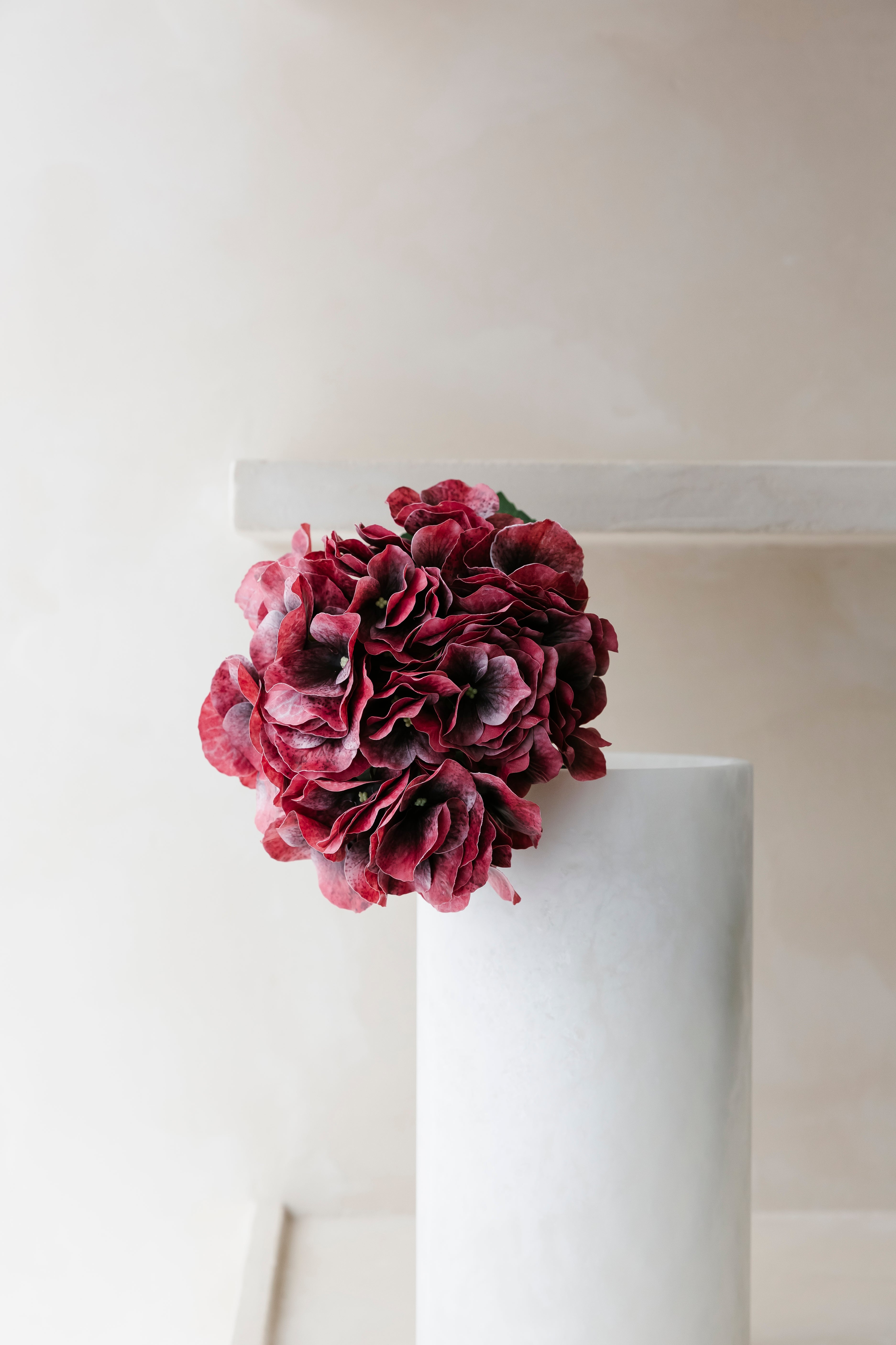 Close-up van zijdebloem hortensia in burgundy kleur in vaas uit Albast van het merk Botané- Collectie Anneke Crauwels