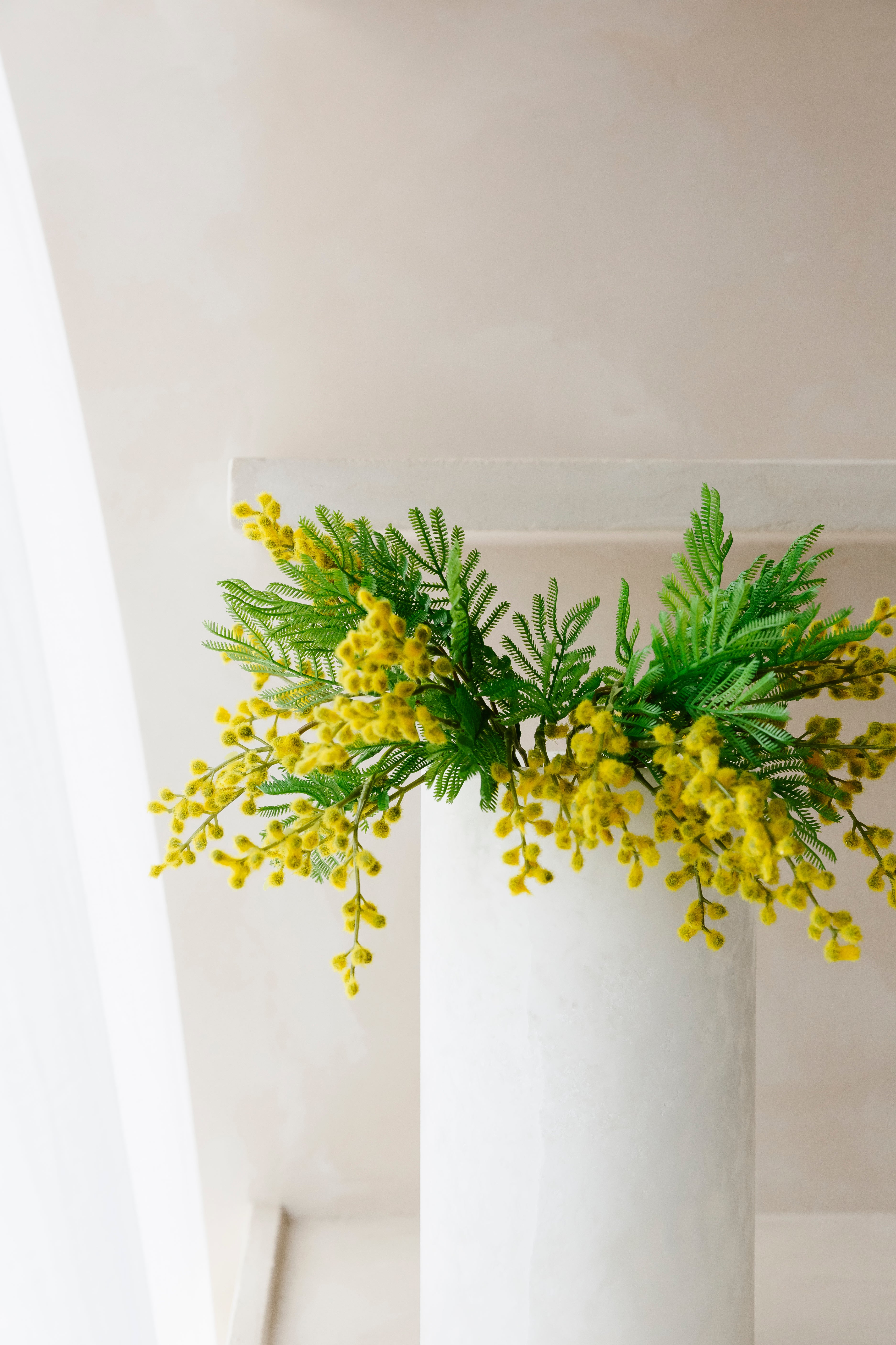 Close-up van een mini mimosa boeket in een vaas uit Albast van het merk Botané- Collectie Anneke Crauwels